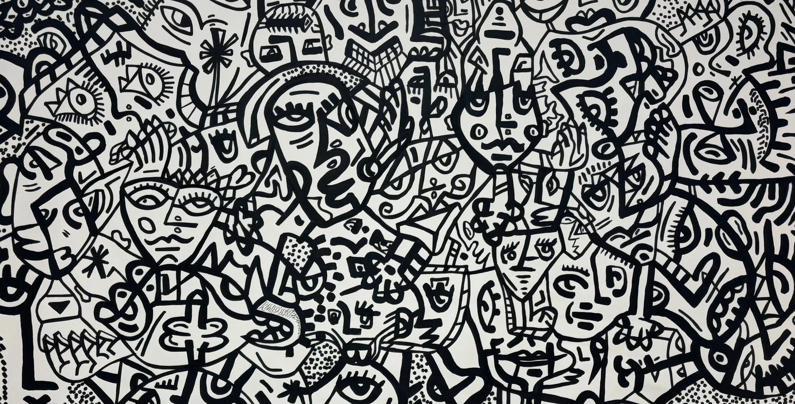 Multitud de rostros y formas entrelazados, dibujados con trazo negro grueso sobre fondo blanco, en un formato alargado. Barcelona city. Acrílico sobre lienzo, 200 x 90 cm, 2026. Barcelona. Nicolás Lapadula