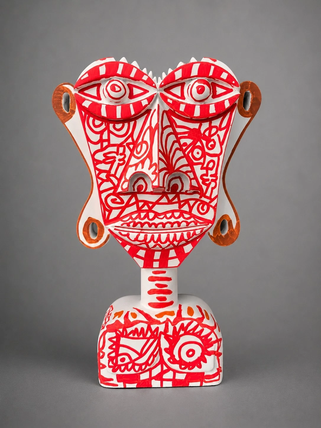 Busto blanco de rostro plano y ojos grandes, cubierto de dibujos lineales en rojo. Busto. Acrílico sobre resina, 28 x 18 x 10 cm, 2026. Caracas. Nicolás Lapadula