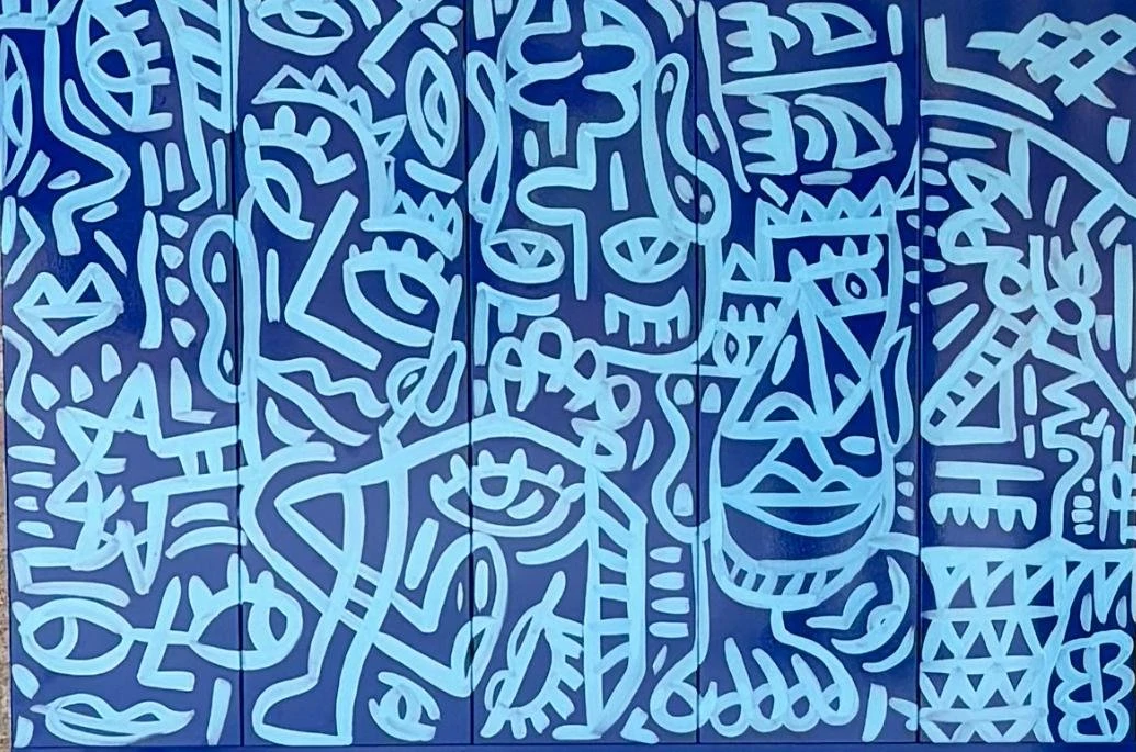 Paneles azul oscuro con rostros, ojos y figuras dibujados en trazo azul claro, unidos en una sola superficie. Sin título. Esmalte sobre hierro, 140 x 100 cm, 2024. Caracas. Nicolás Lapadula