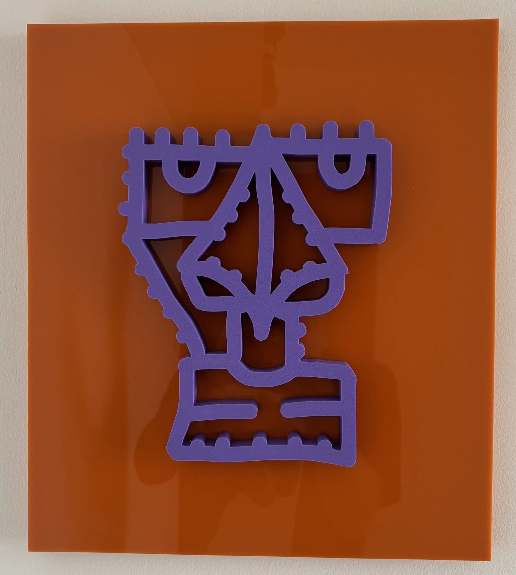 Rostro de trazo continuo impreso en 3D, de color morado, sobre una placa de acrílico naranja colgada de una pared blanca. Sin título. Impresión 3D sobre acrílico, 35 x 40 cm, 2026. Caracas. Nicolás Lapadula